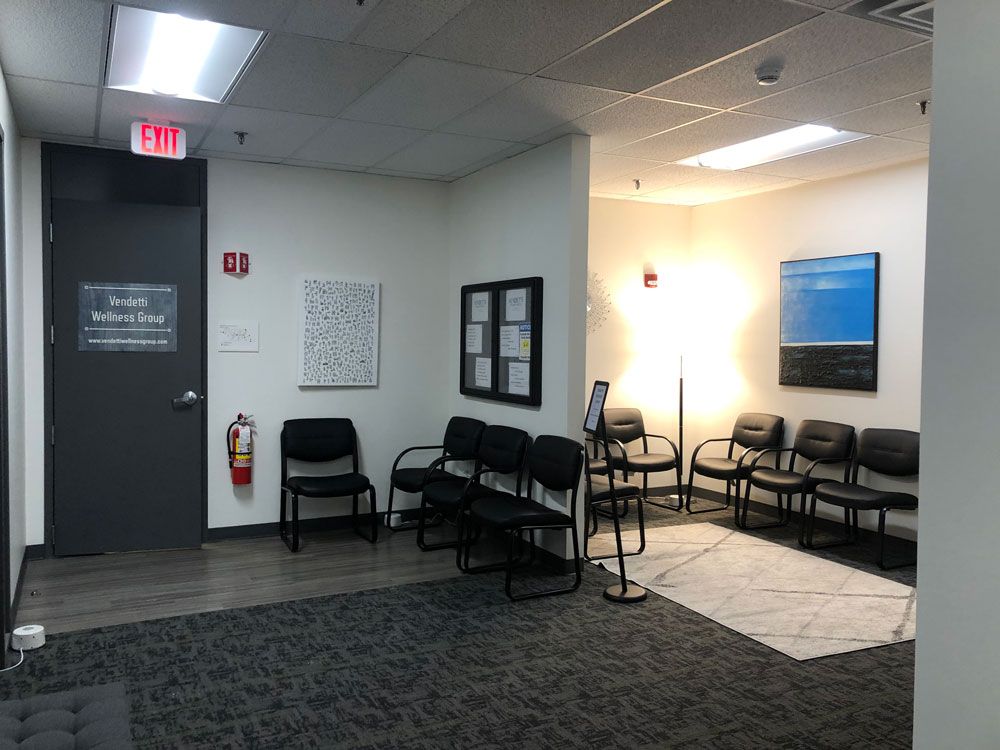 A waiting room with chairs and an exit sign.