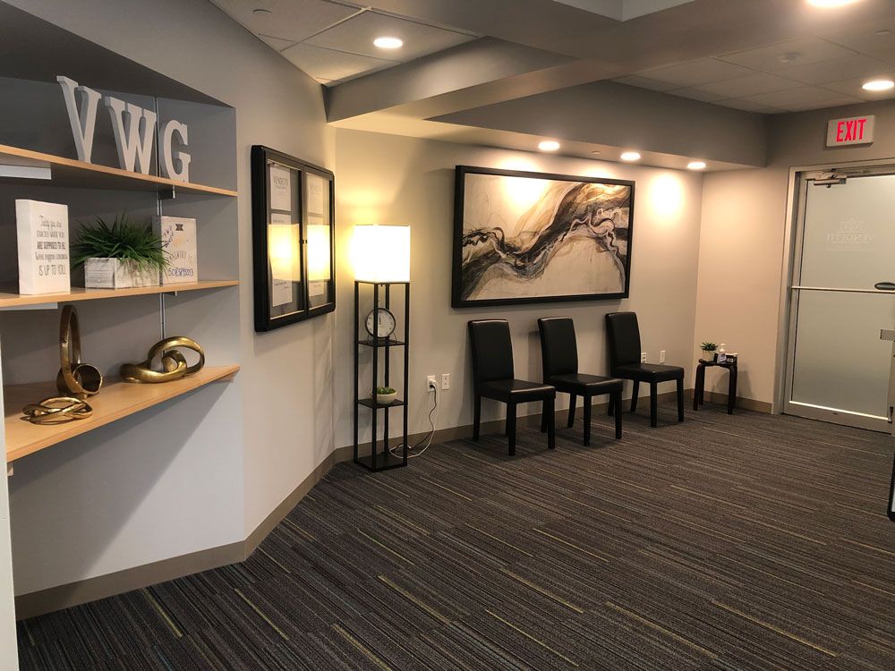 A waiting room with chairs and a picture on the wall.