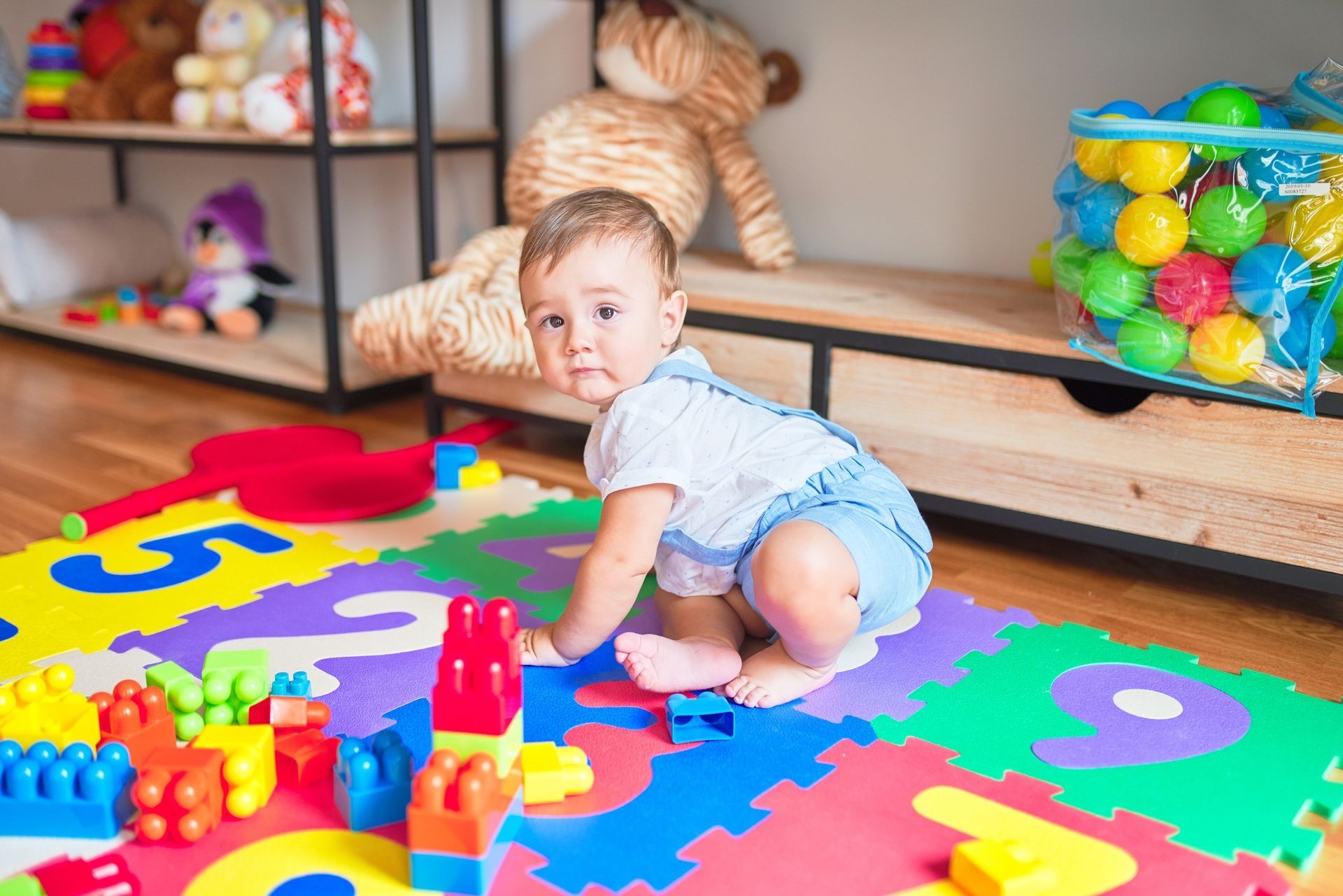 Toddler Sitting on Puzzle Carpet – Mendon, NY – Mendon Child Care Center