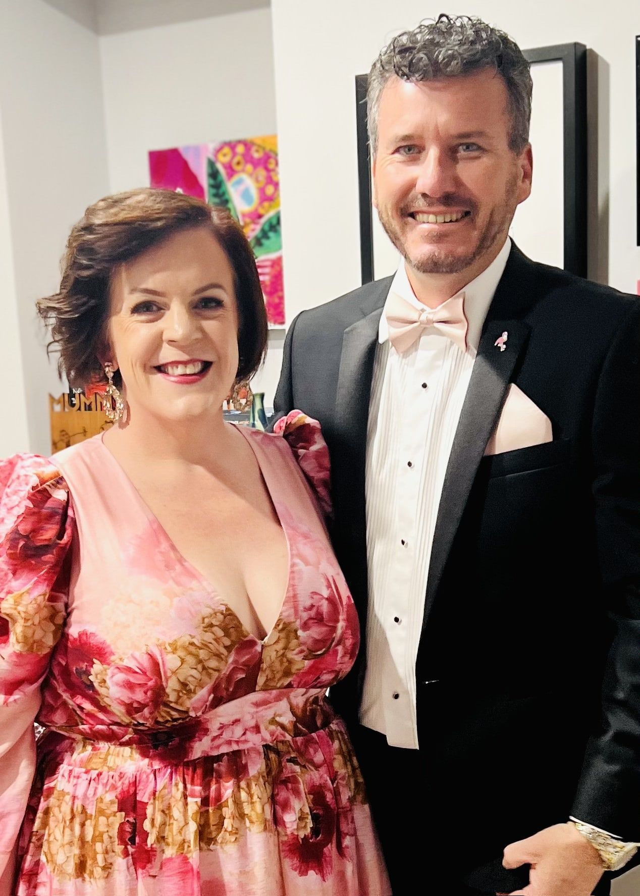 clayton menyweather in a tuxedo and emma menyweather in a pink dress are posing for a picture .