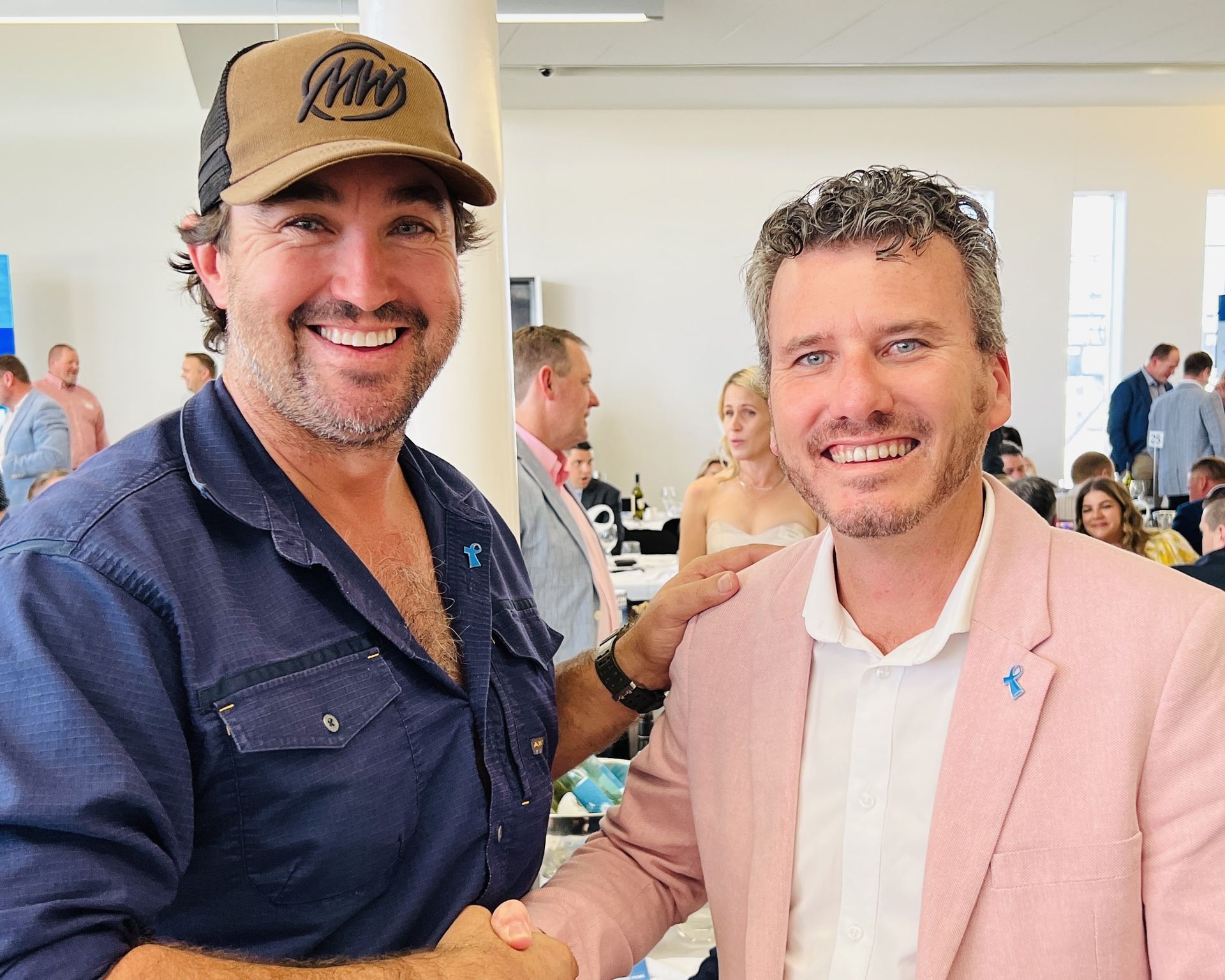 clayton menyweather and another man in a hat are shaking hands in a room