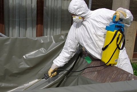 man spraying asbestos solution