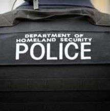 A police officer is wearing a black vest with the word police on it.