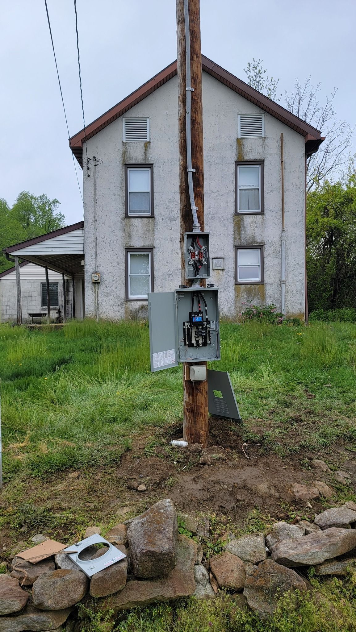 A house with a telephone pole in front of it.