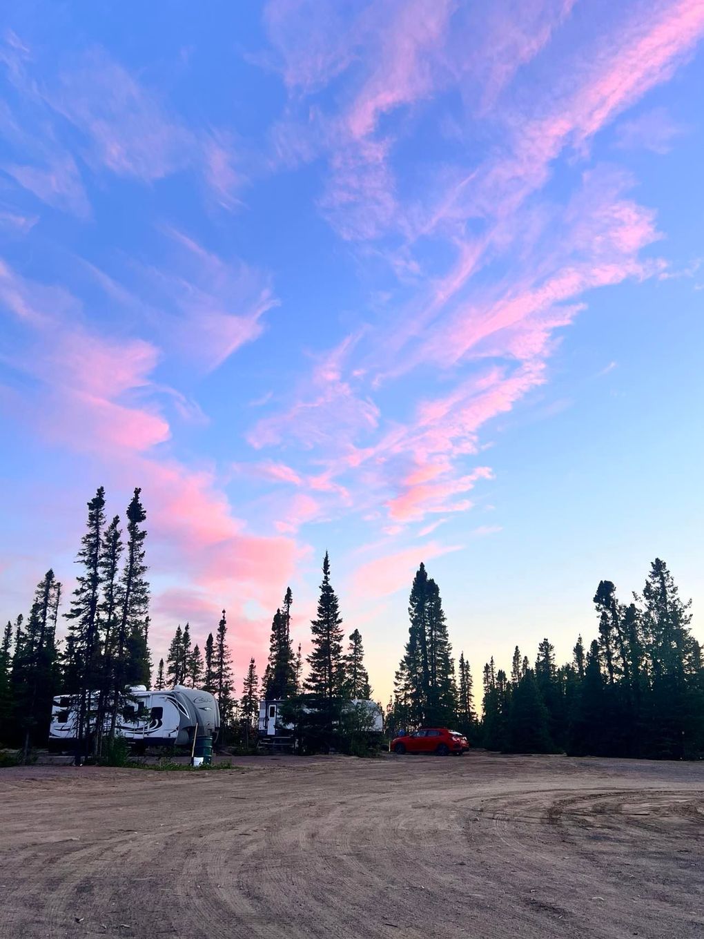 A sunset with a lot of trees in the foreground