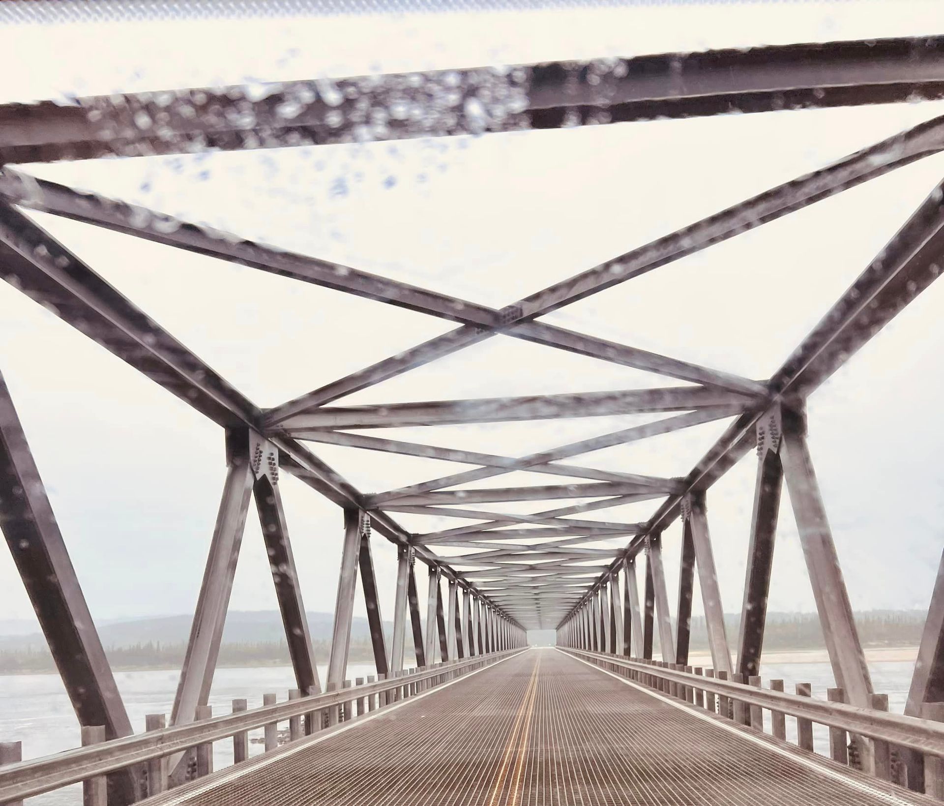 A bridge over a body of water with snow falling on it