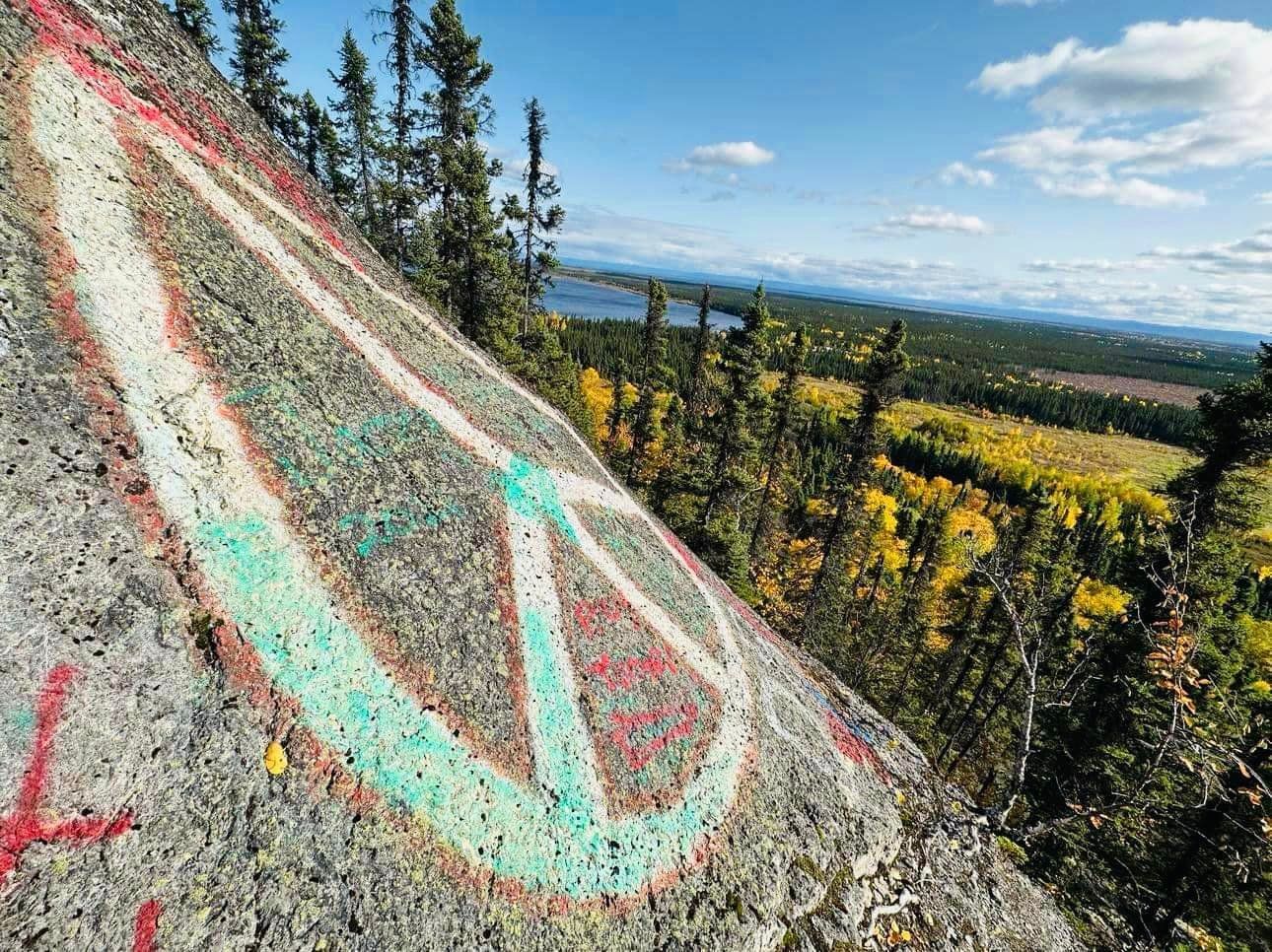 A rock with a red , white and green arrow painted on it.