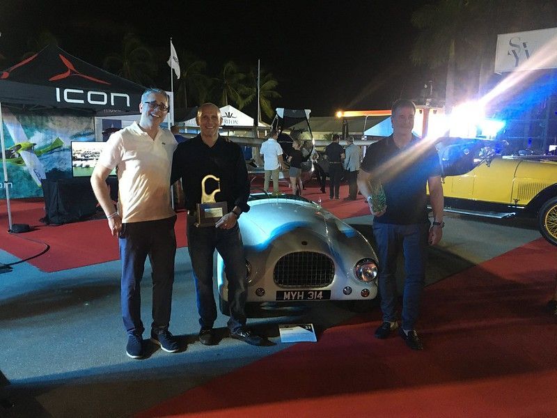Three men standing in front of an icon tent