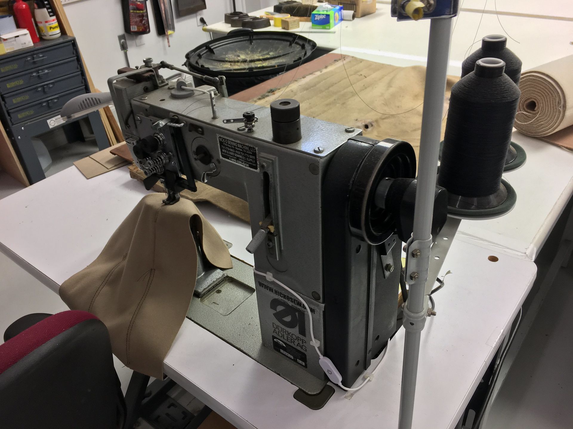 A sewing machine is sitting on top of a white table.