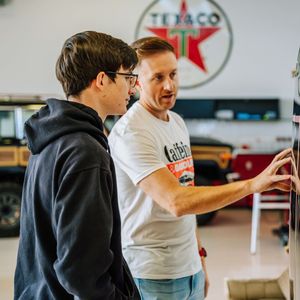 Two men are standing in front of a texaco sign