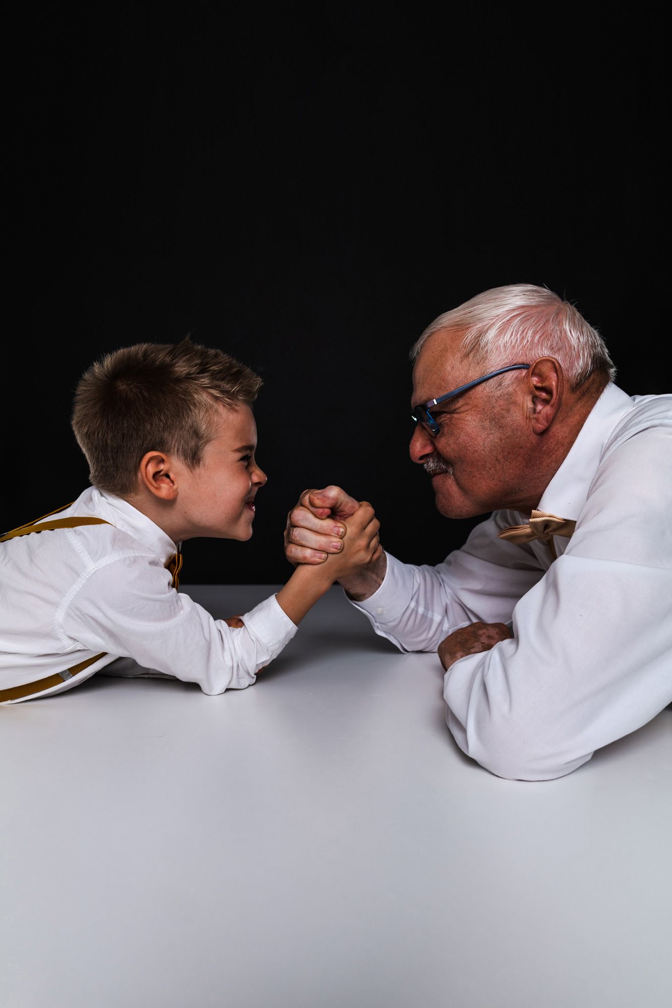 Fotoshooting mit Enkelkind und Opa beim Armdrücken