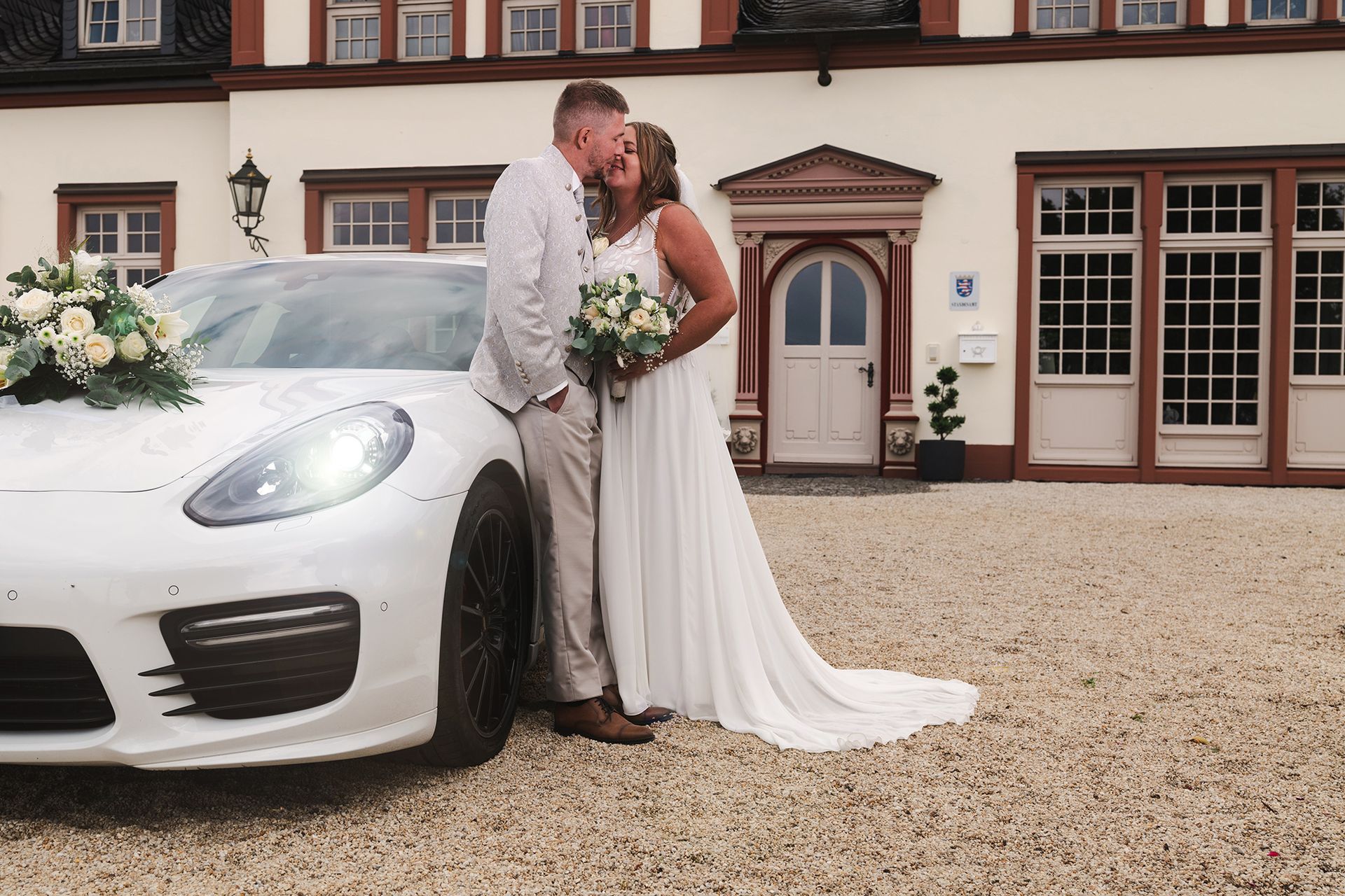 Das Brautpaar am Hochzeitsauto