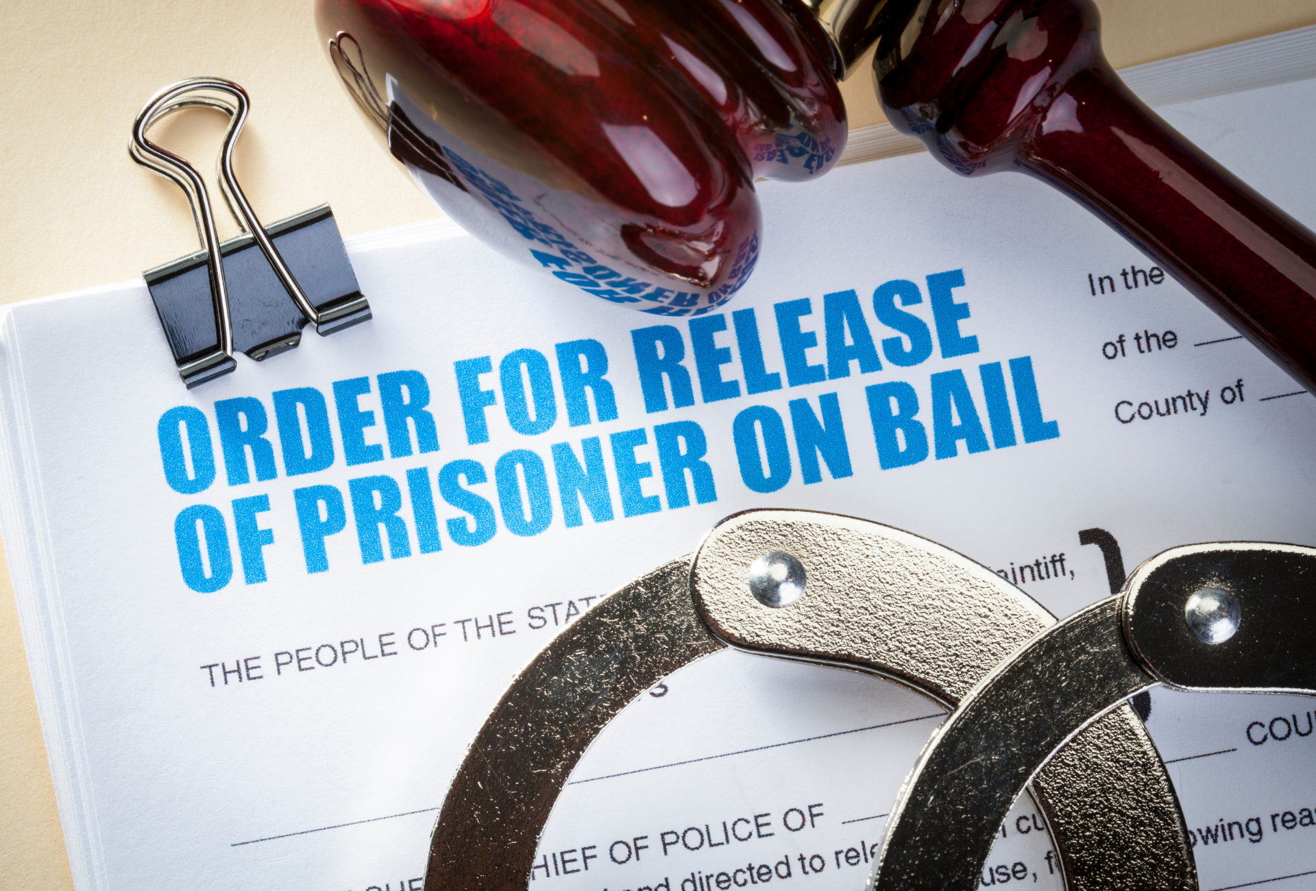 Order for release of prisoner on bail document with handcuffs, gavel, and paper clip.