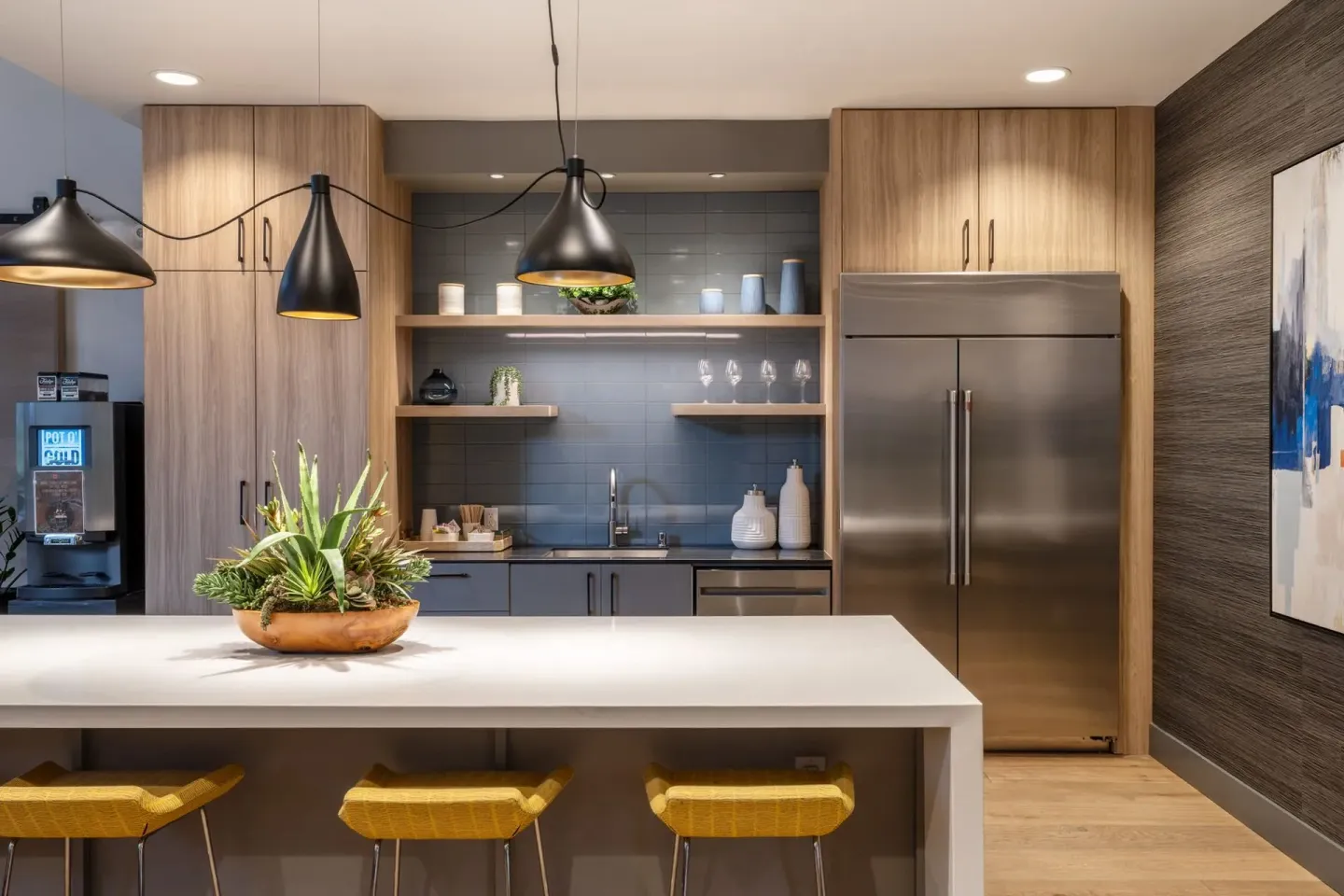 Modern kitchen with island, stainless steel fridge, and black pendant lights at Park Bellevue, offering apartments for rent in Bellevue, WA.