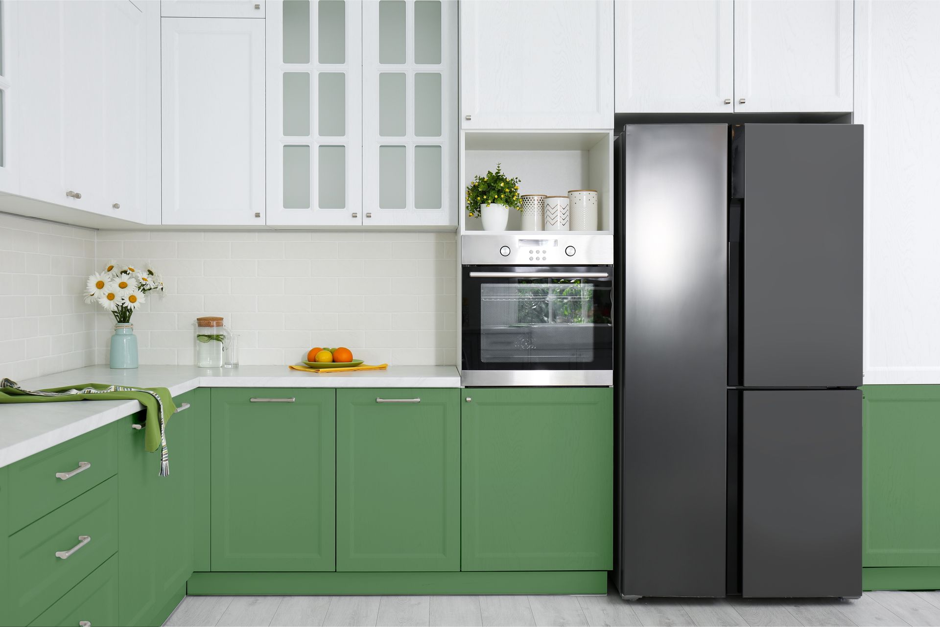Green and white kitchen with a gray refrigerator, cabinets, and built-in oven.