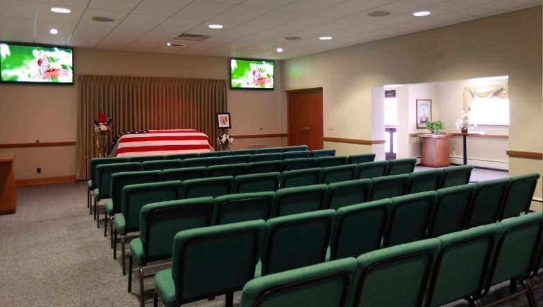 A row of green chairs in a funeral home