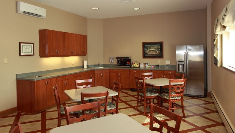 A kitchen with tables and chairs and a refrigerator