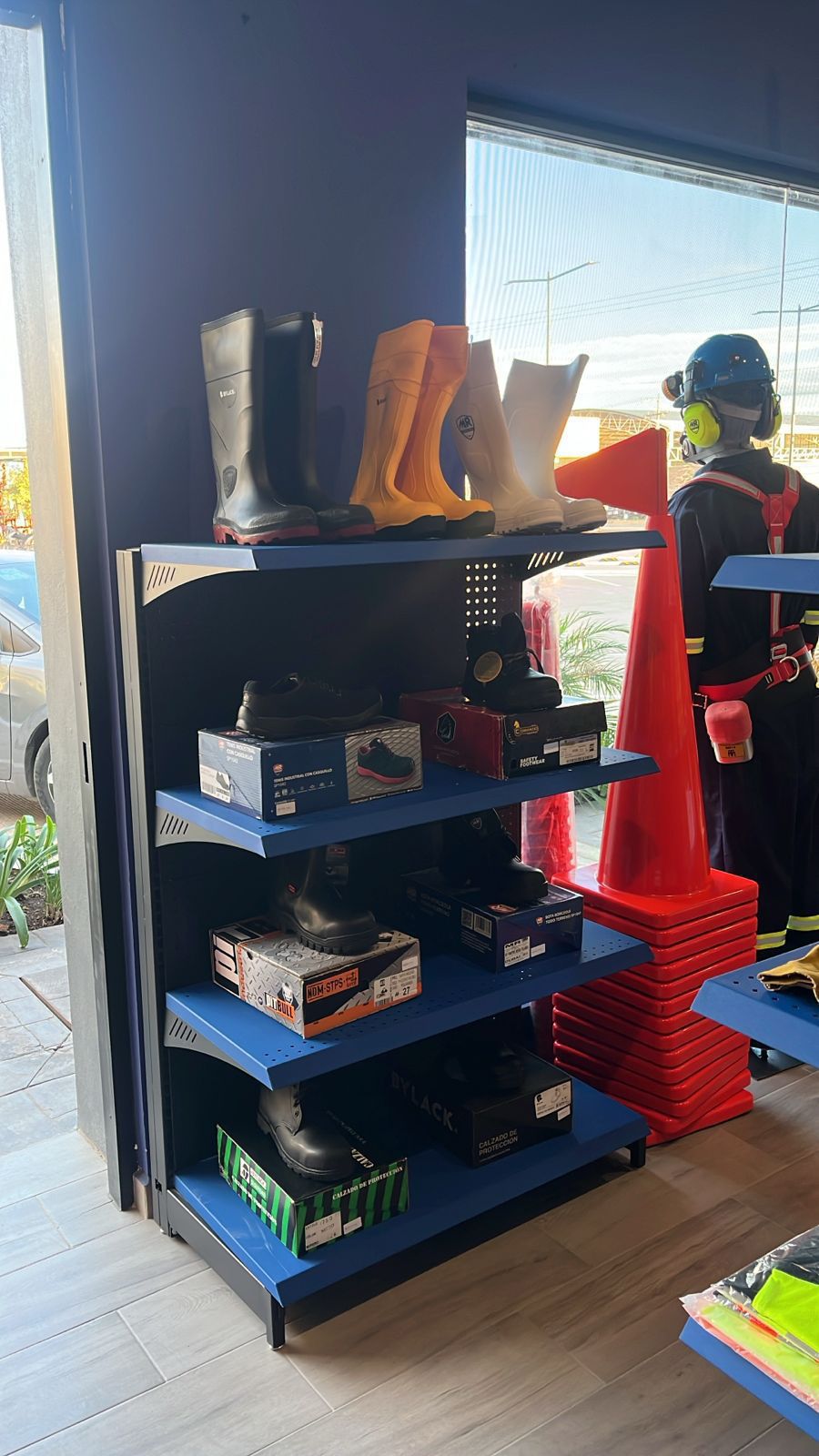 Una tienda llena de equipos de seguridad, incluidas botas y guantes.
