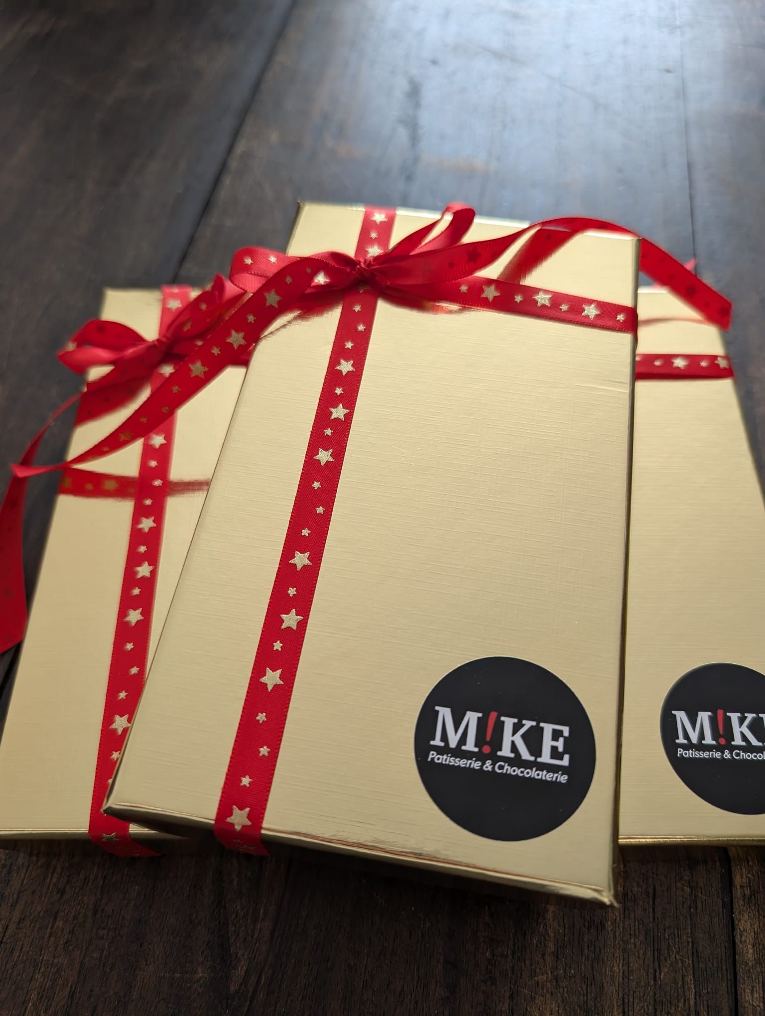 Adventskalender van hout met blokken in verschillende vormen en kleuren, die iemand voor het raam vasthoudt.