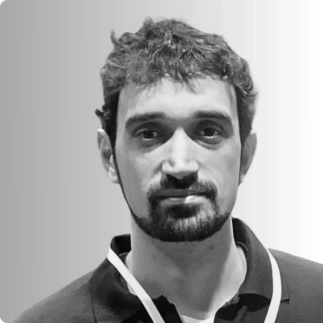 Um homem está sorrindo em uma foto em preto e branco.