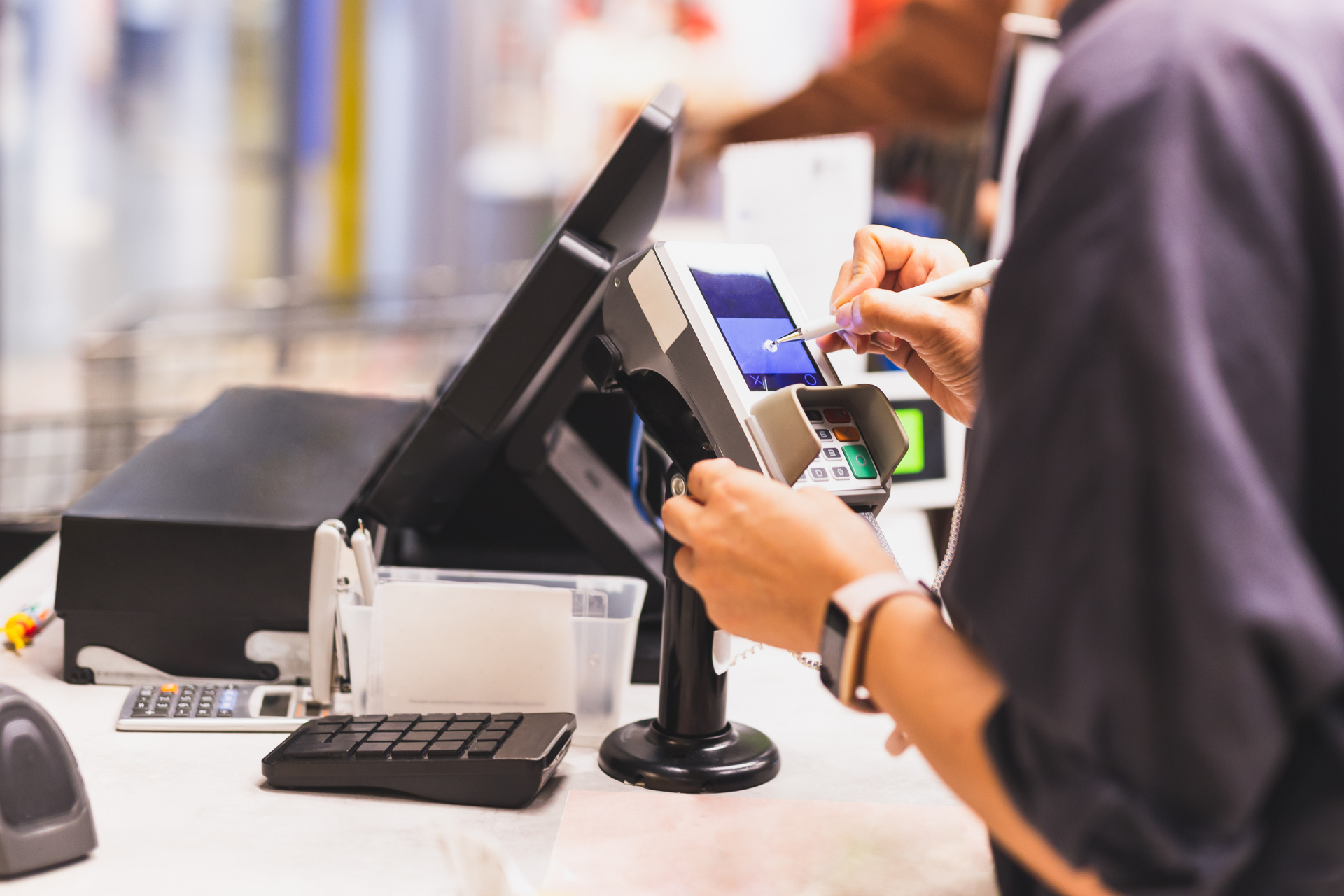 A person is using a credit card to pay at a cash register.