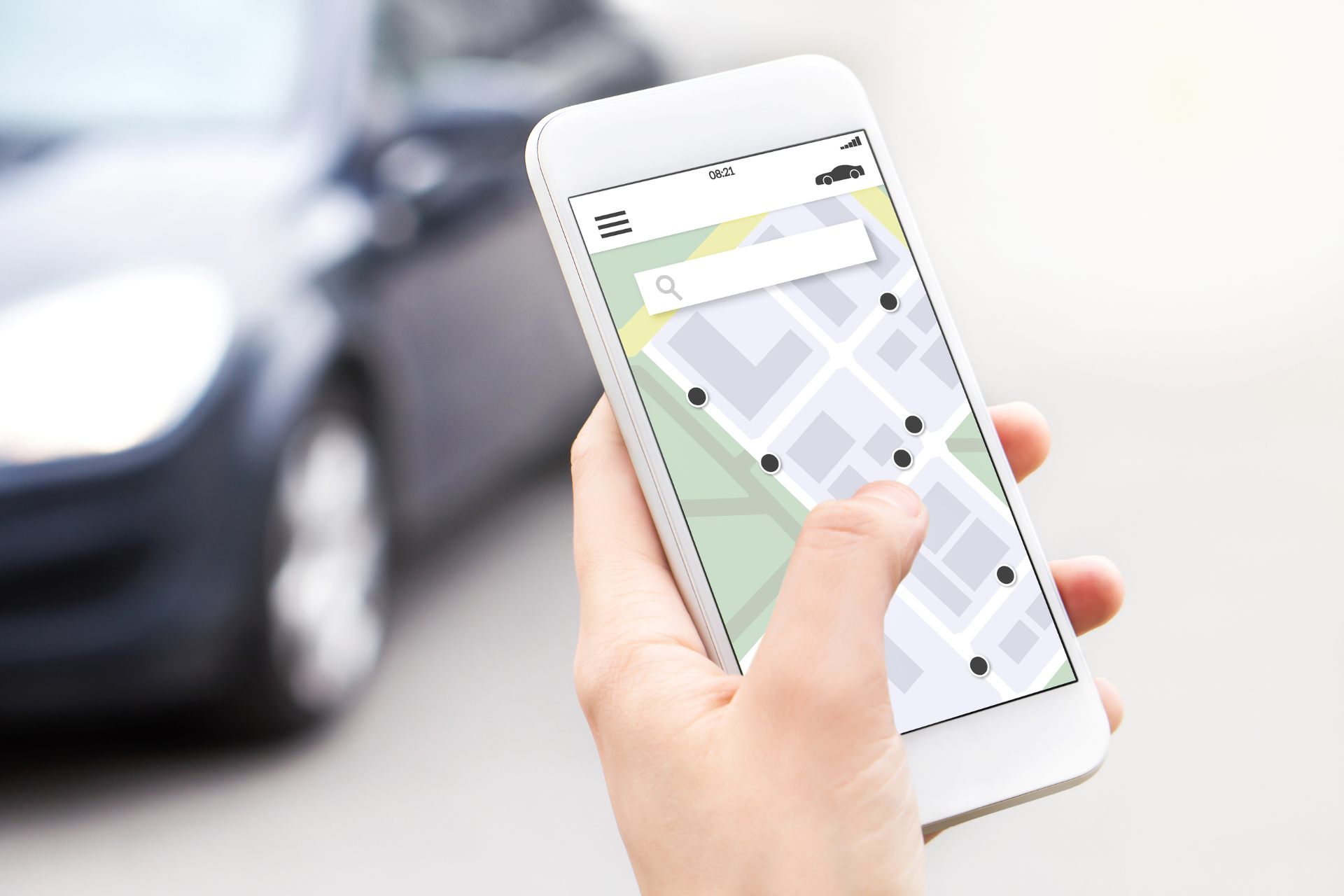 A person is holding a cell phone with a map on it in front of a car.