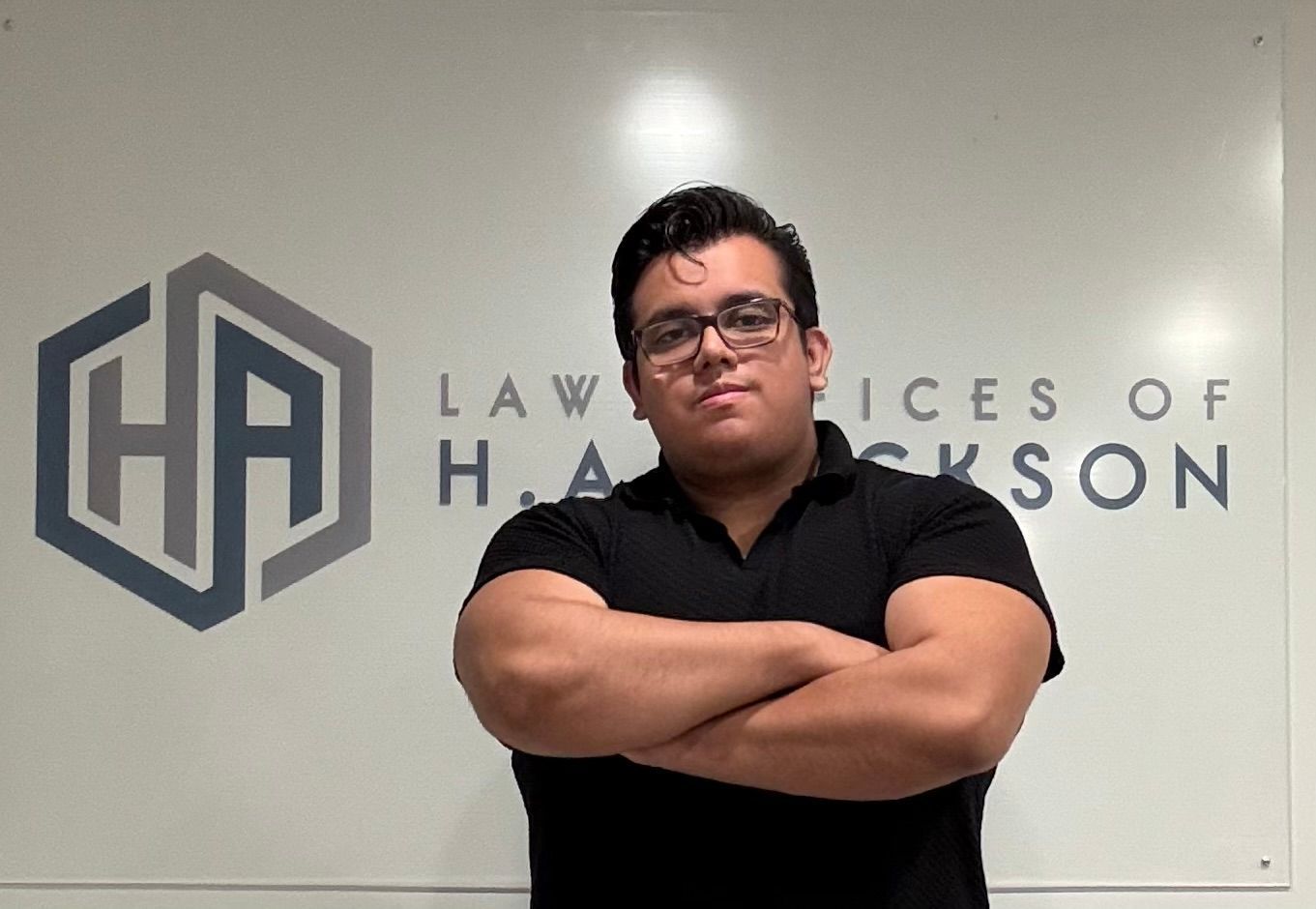 A man is standing in front of a sign that says law offices of hackson