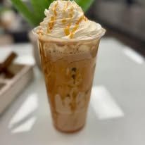 Iced caramel frappuccino topped with whipped cream in a clear plastic cup