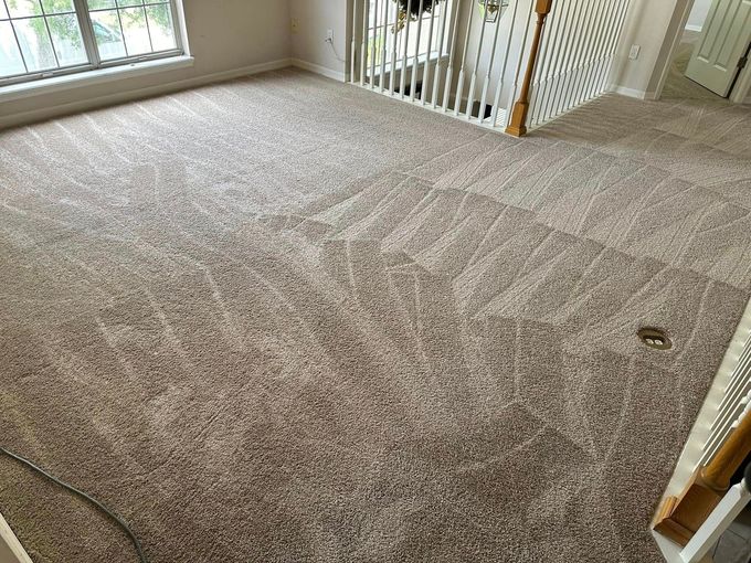 A living room with a carpeted floor and stairs.