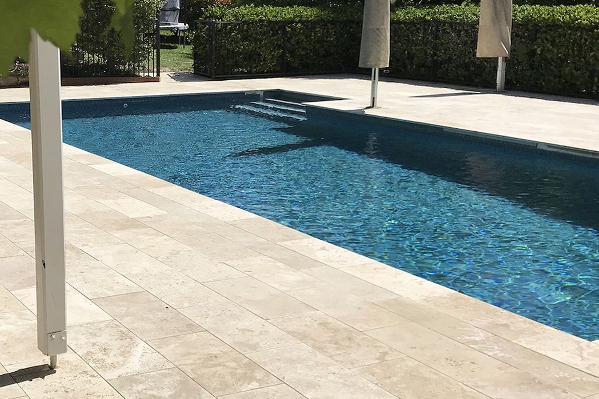 A large swimming pool with umbrellas in the background