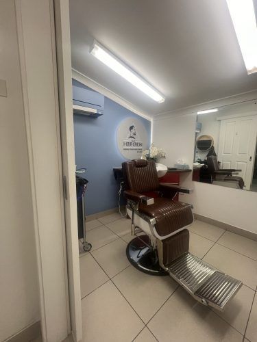 There is a barber chair in the middle of the room.