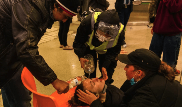 A woman being treated after australian police use pepper spray