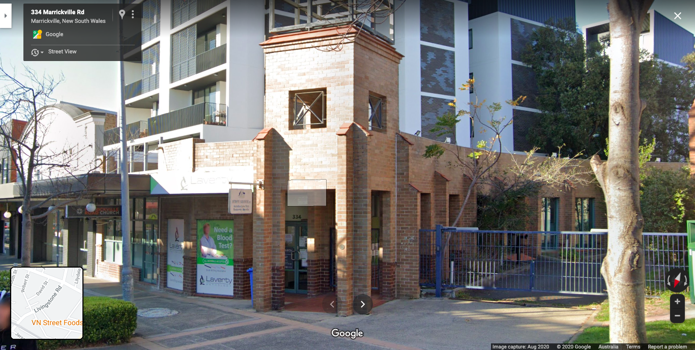 A building with a tower on top of it is on the corner of a street.