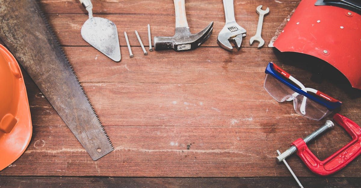 A wooden table topped with a variety of tools and a hard hat from APXC Group.