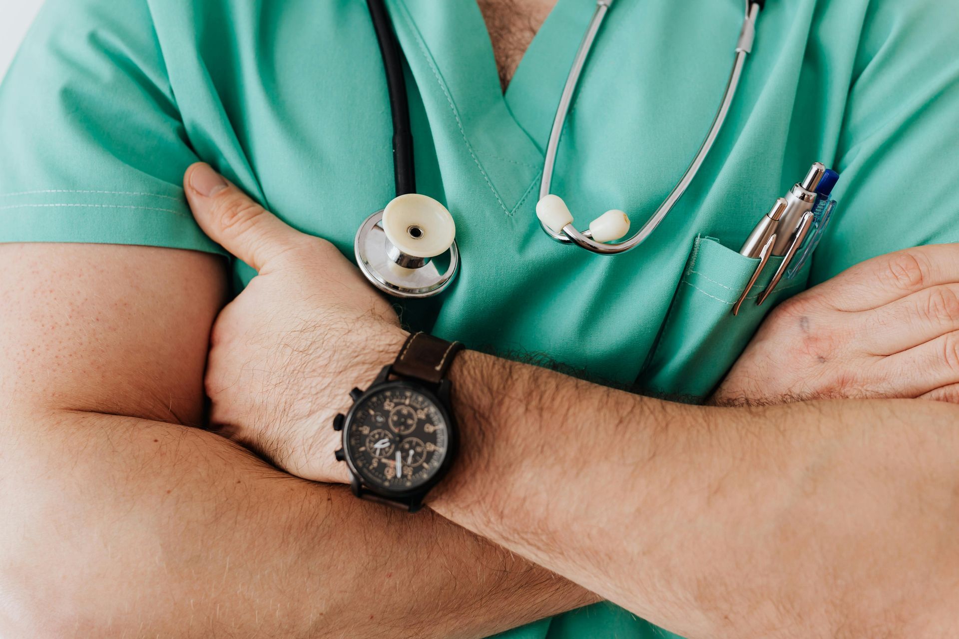 The doctor is wearing a watch and a stethoscope around his neck.