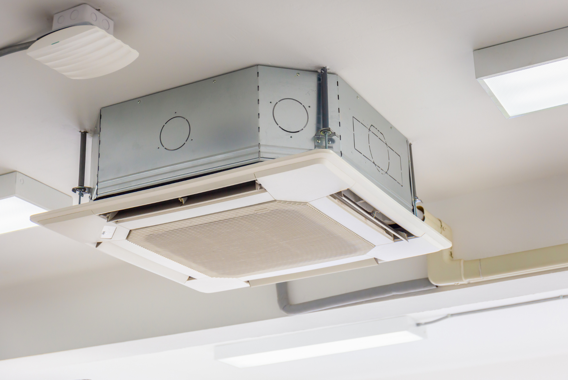 A close up of a ceiling mounted air conditioner in a room.