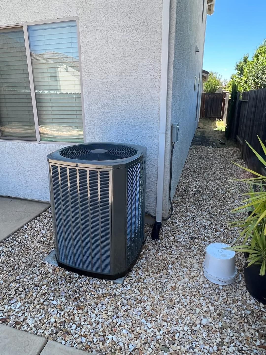 A large air conditioner is sitting on the side of a house.