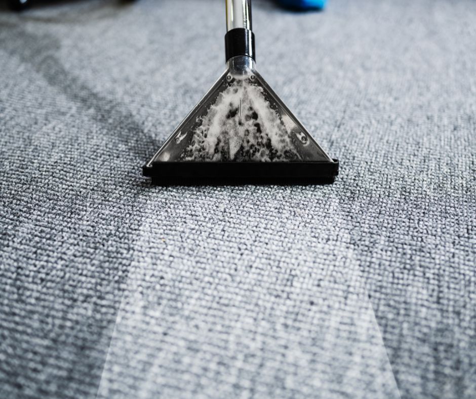 An industrial carpet cleaner in Lewisham South London hard at work. A blue carpet with swirls of detergent visible during cleaning.