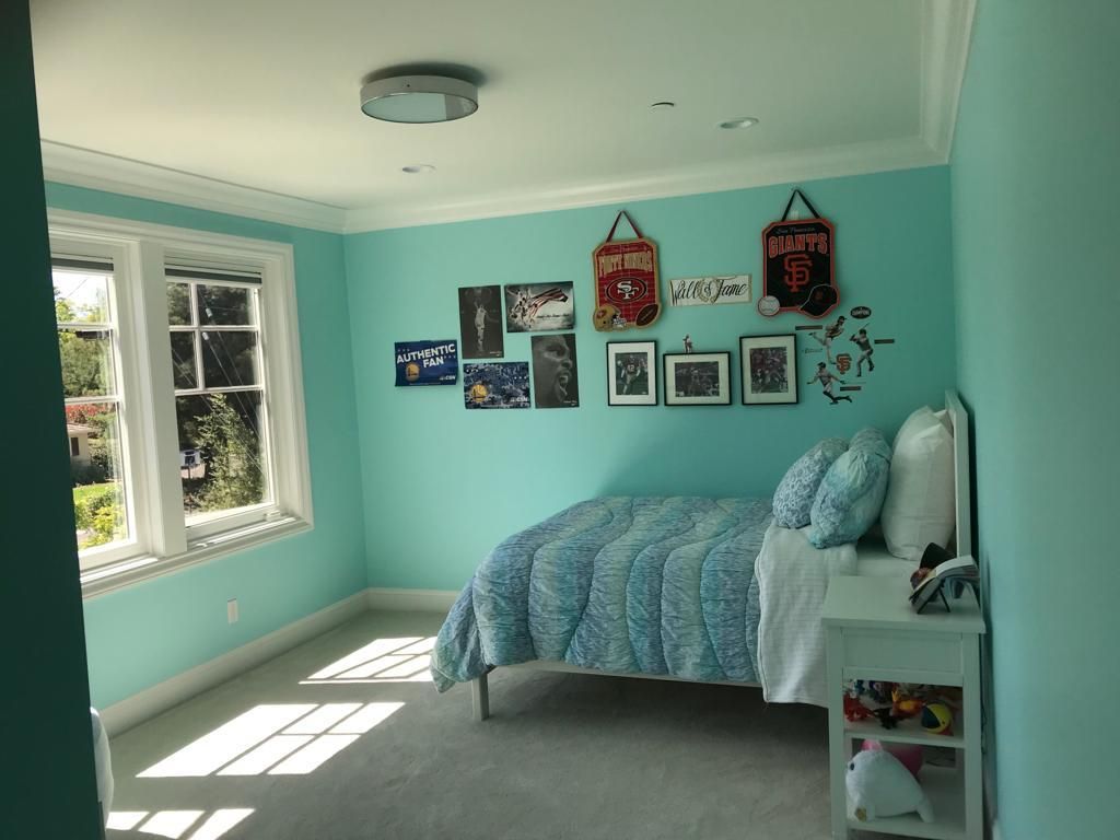 A bedroom with blue walls and a bed