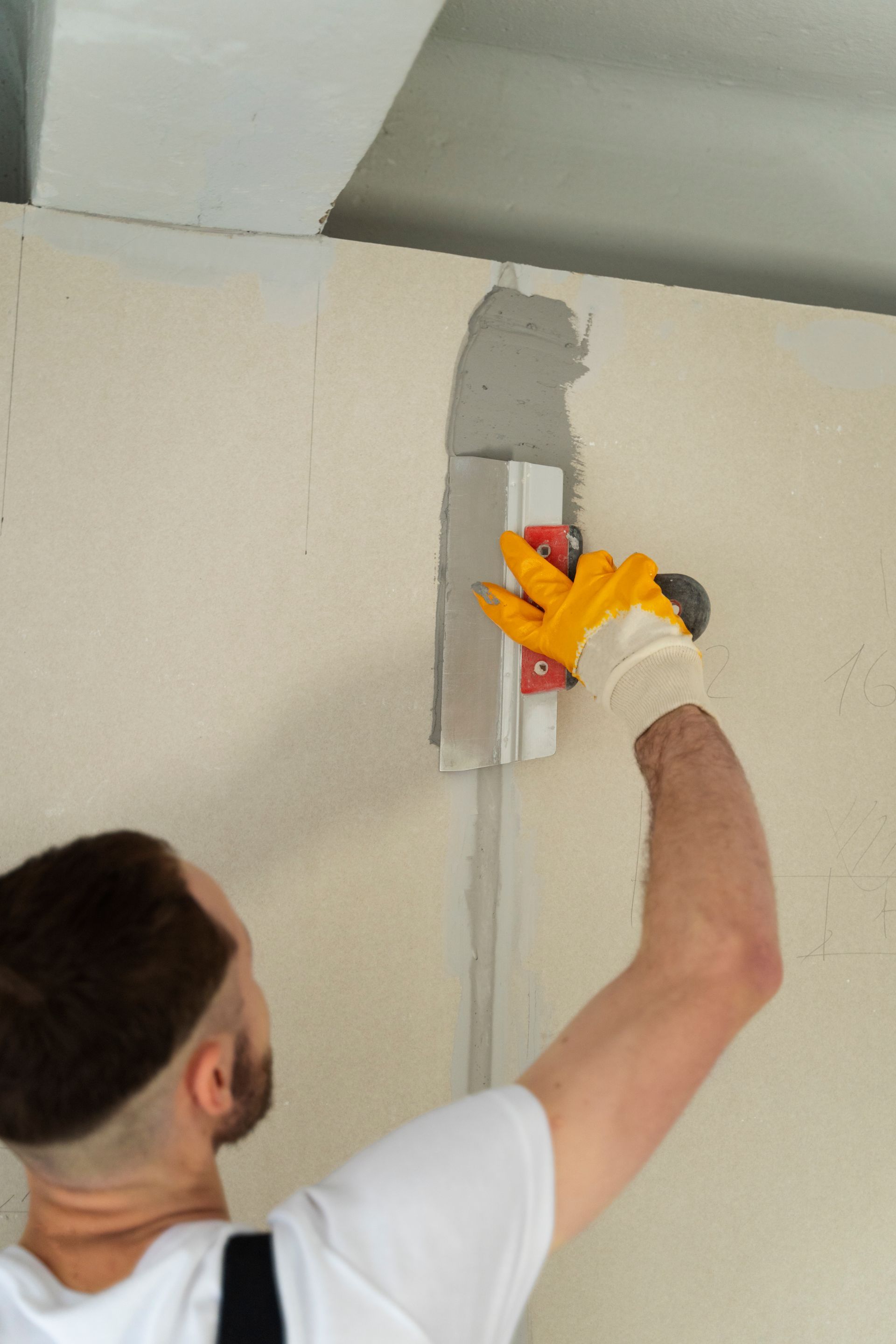 A man is plastering a wall with a trowel.