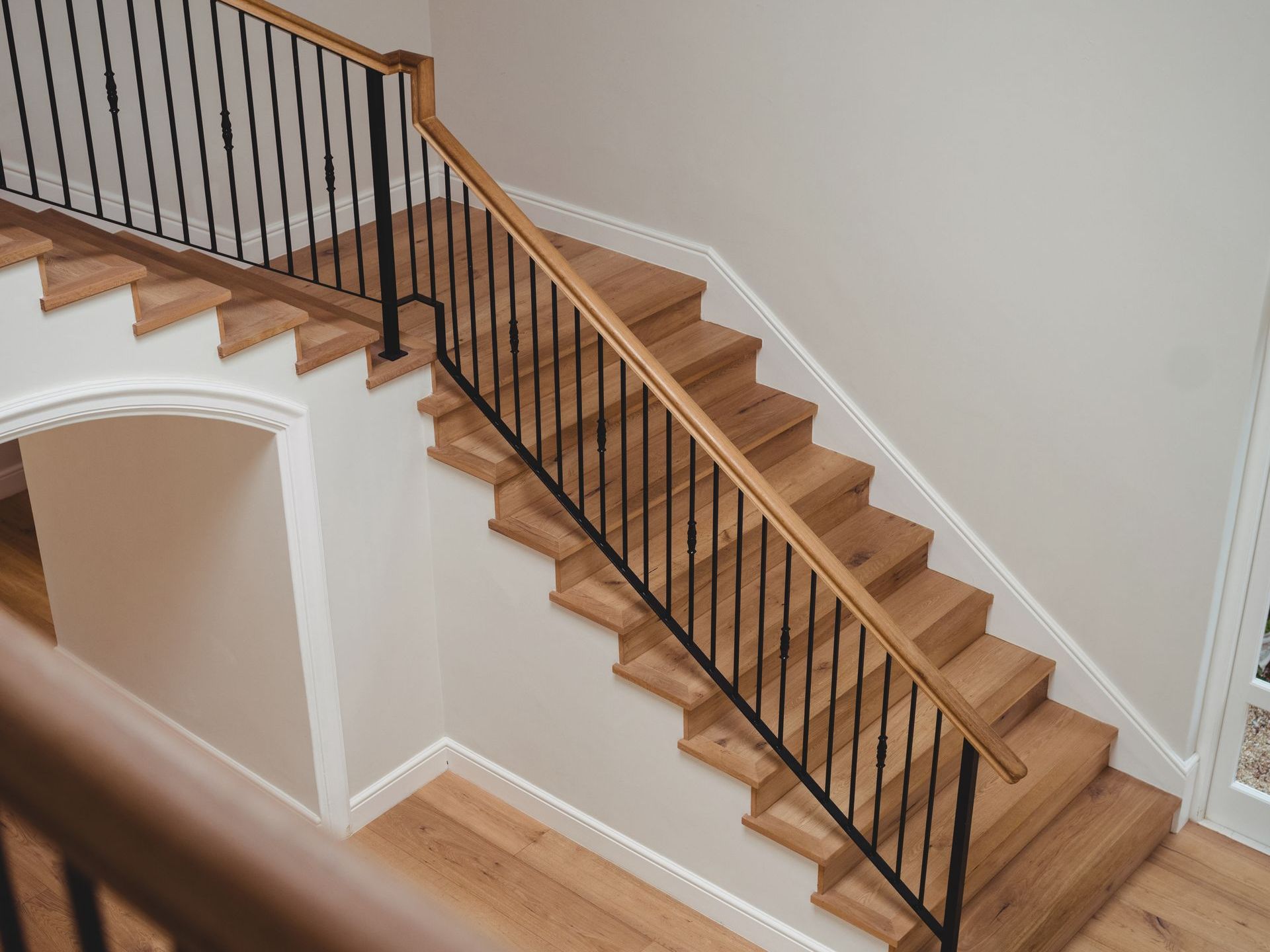 A wooden staircase with a metal railing in a house.