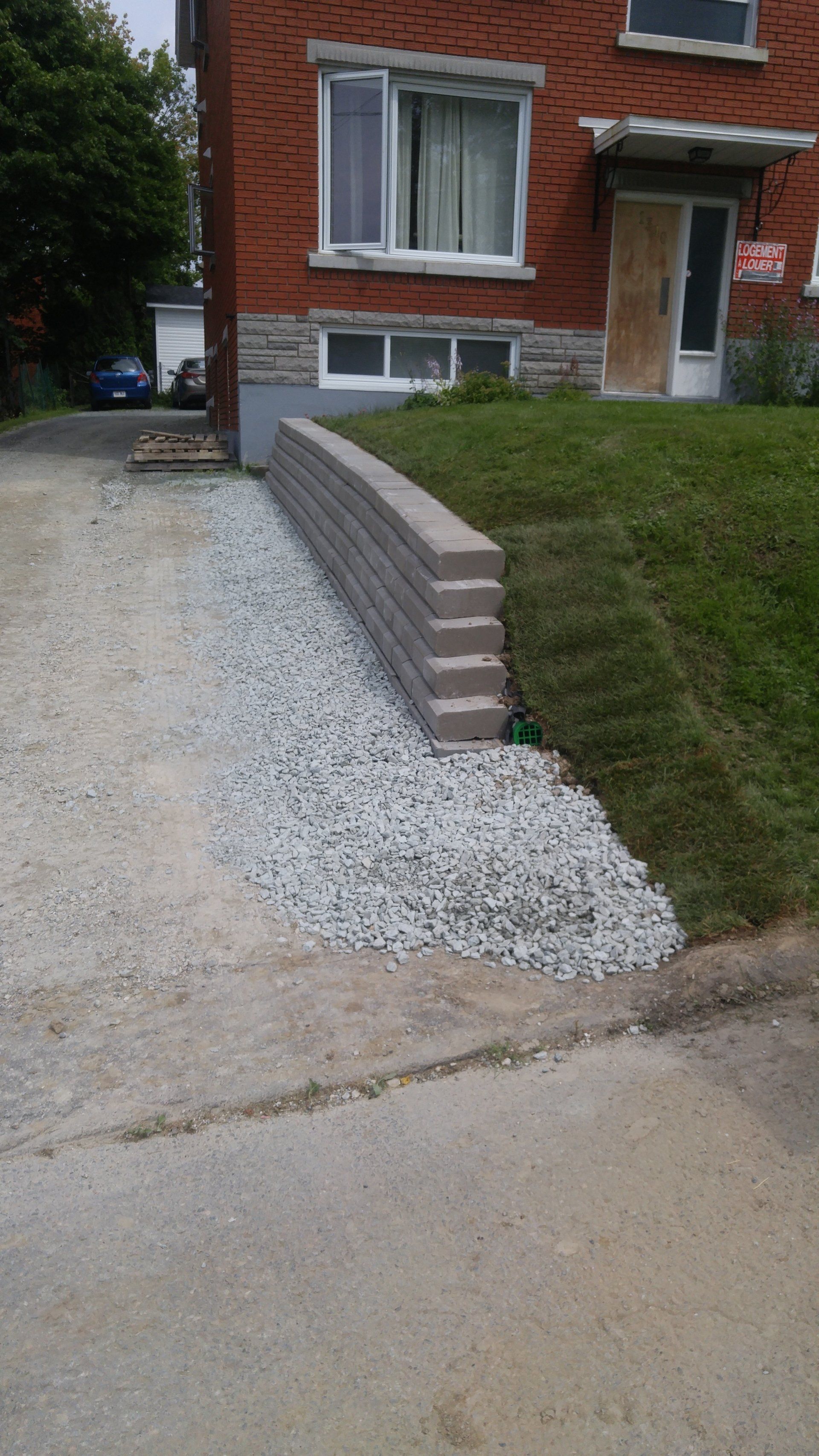 devant de maison avec allée et mur de soutènement