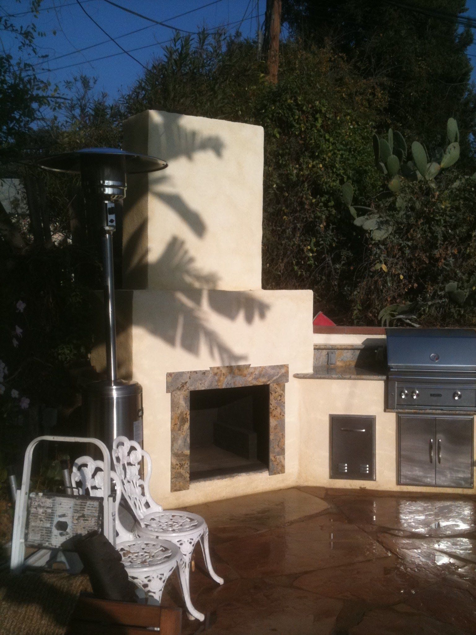 A patio area with a fireplace and a grill