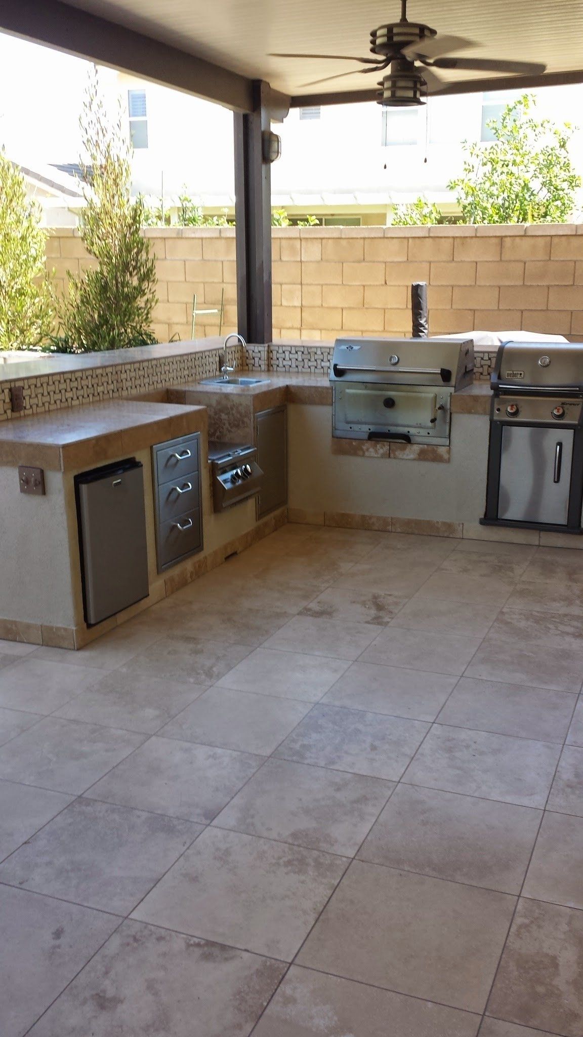 A kitchen with a grill , sink , and ceiling fan.