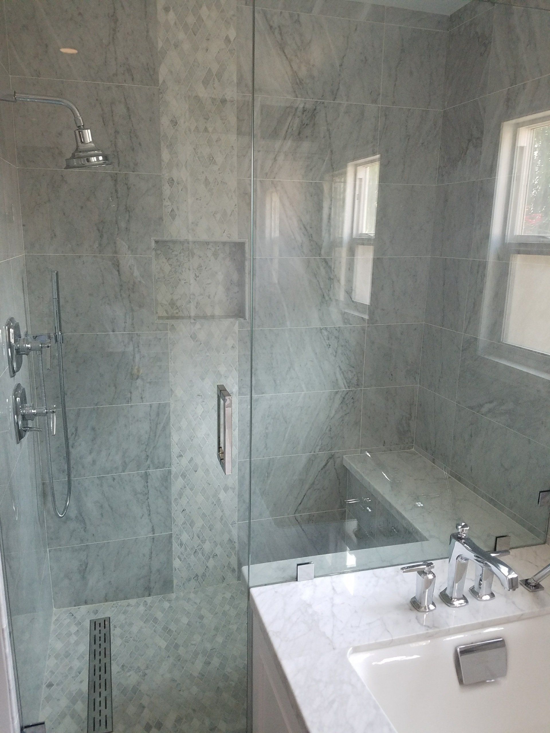 A bathroom with a shower , sink , and mirror.