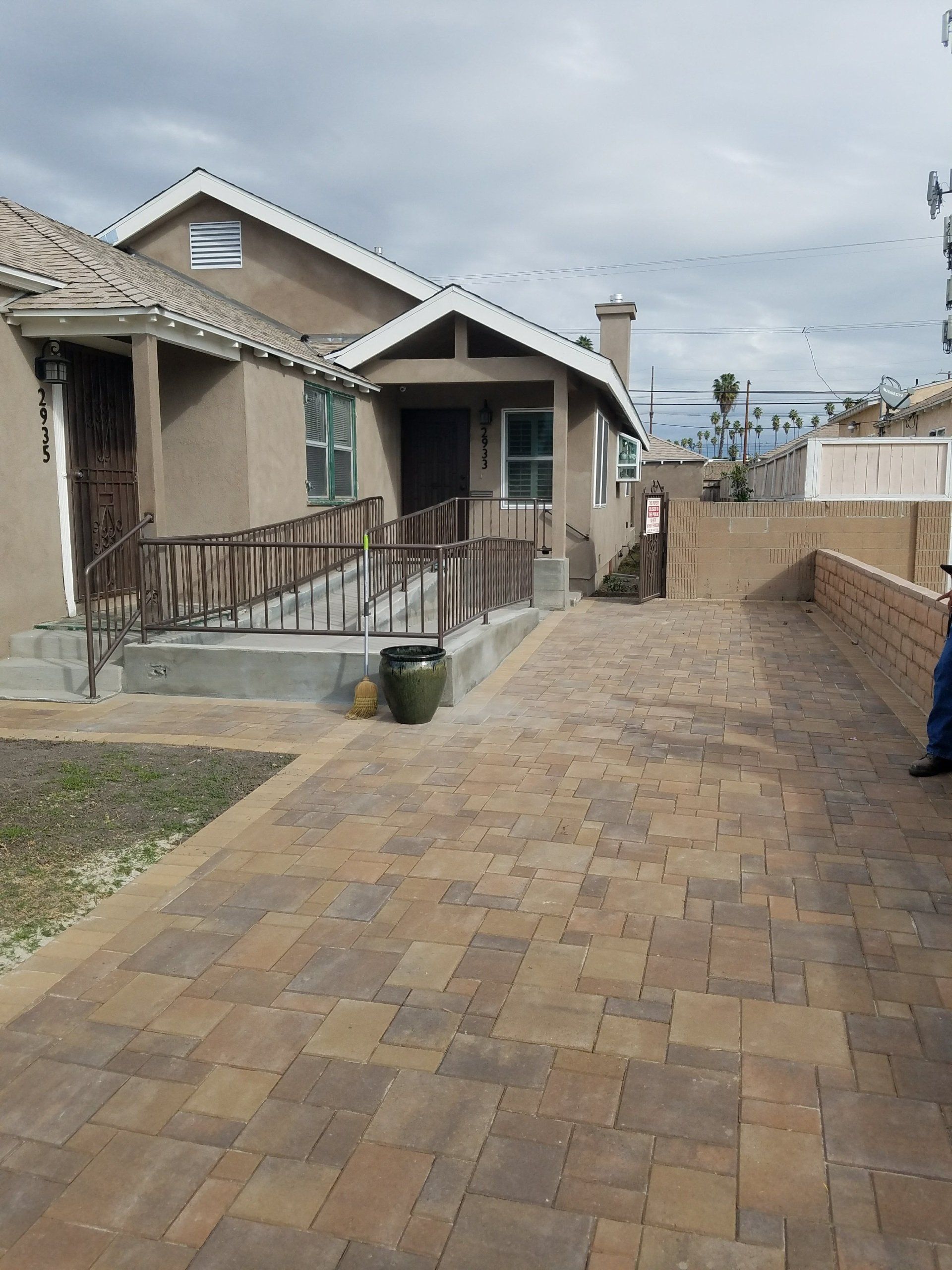 A brick driveway leads to a house with a ramp