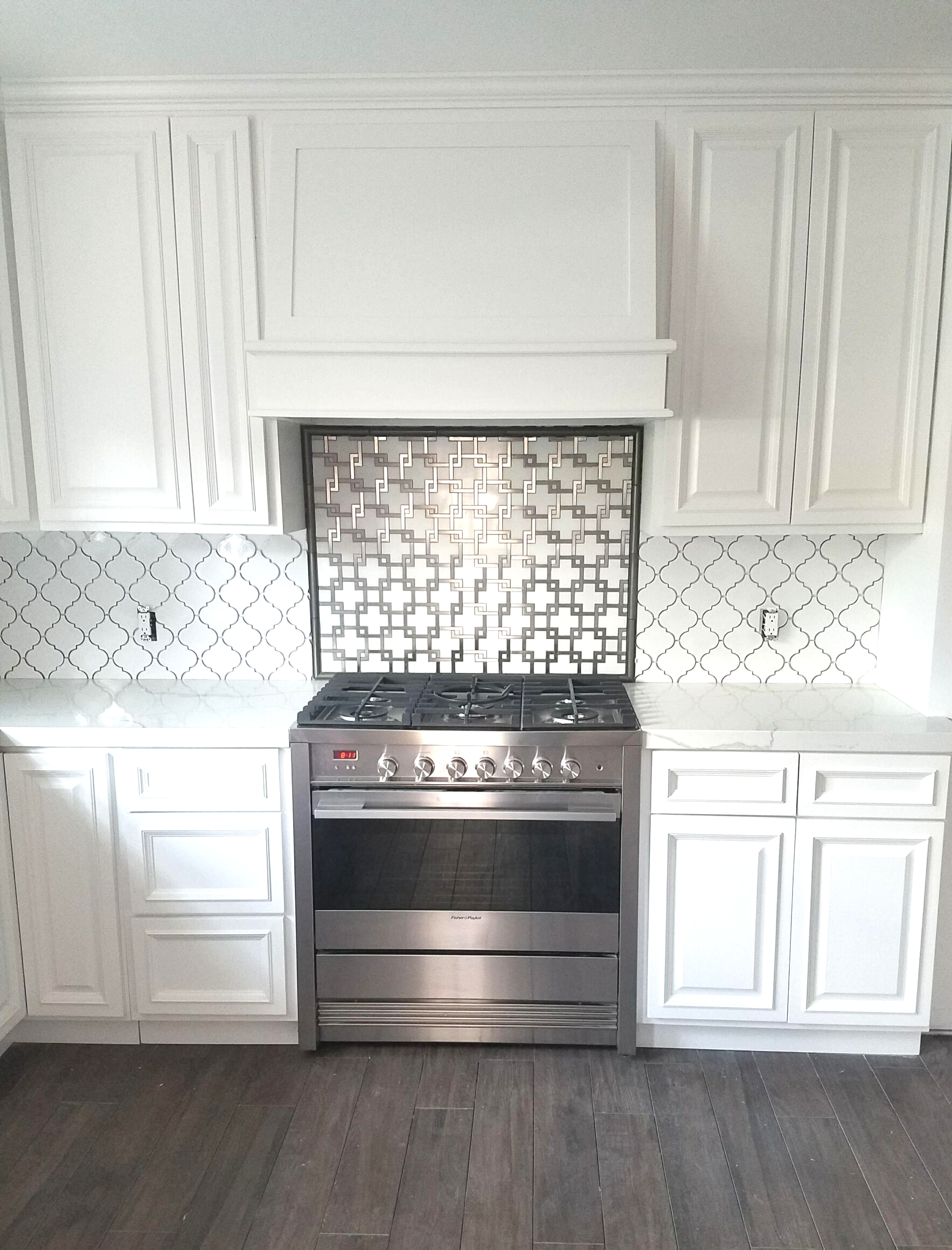 A kitchen with stainless steel appliances and white cabinets