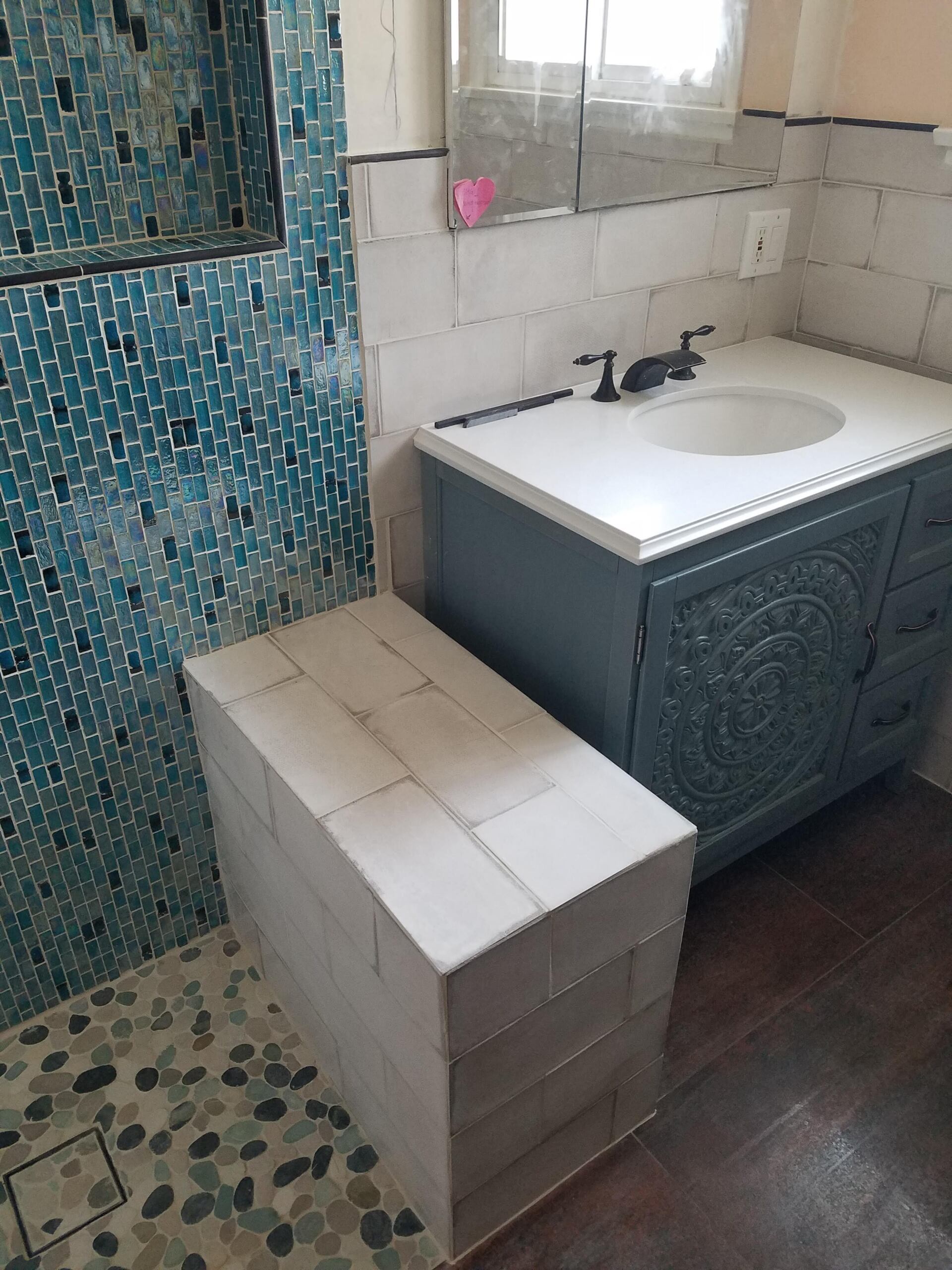 A bathroom with a sink and a walk in shower