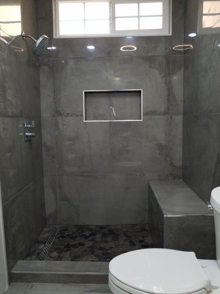 A bathroom with a walk in shower and a toilet