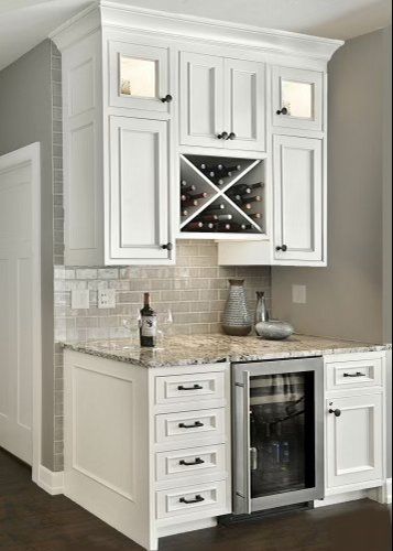 A kitchen with white cabinets and a wine cooler